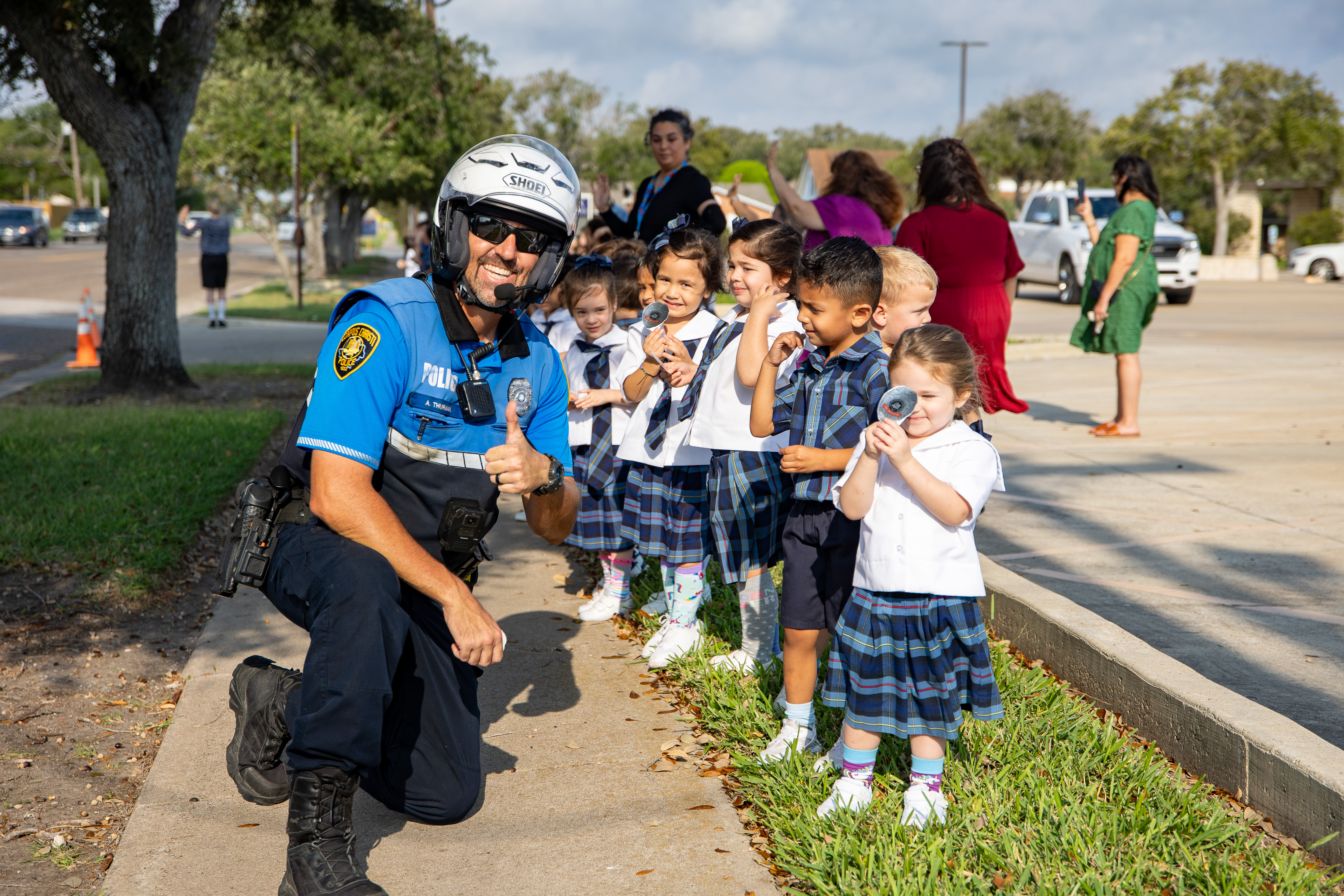 officer with kindergardeners posing and giving thumbs up